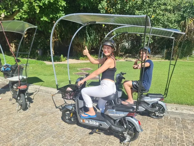 Family on solar e-bikes giving a thumbs up